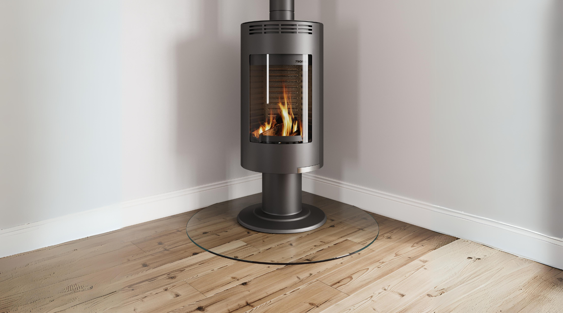 Free-standing wood burner with toughened glass hearth placed on a wood floor.