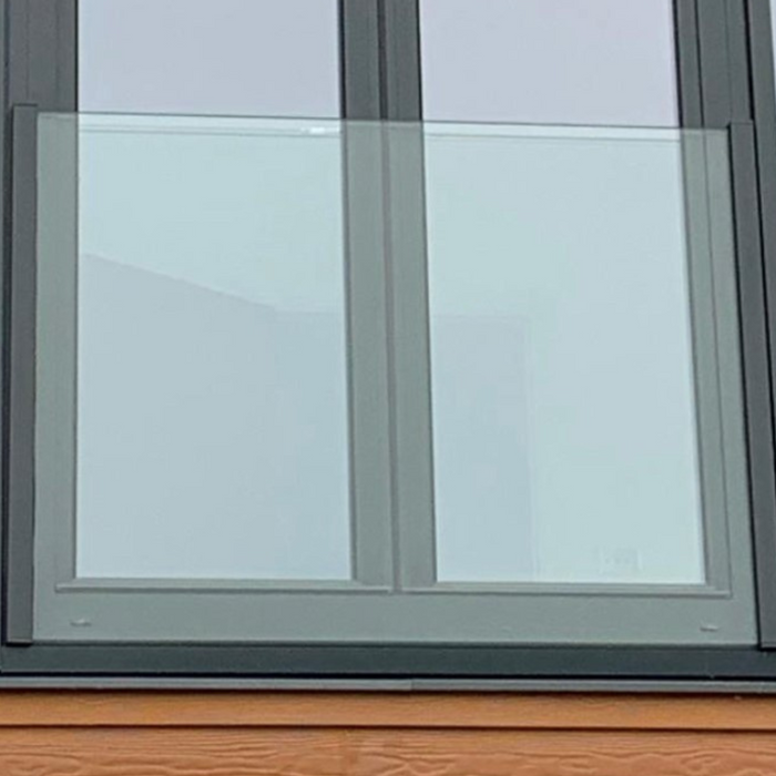 A top mounted Glass juliet balcony on the front of a house.